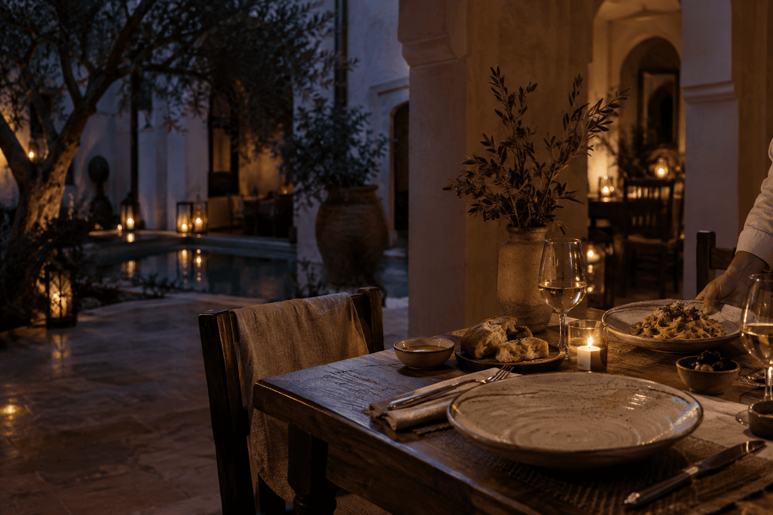 Candlelit table with handmade pasta, focaccia, and warm plaster surroundings